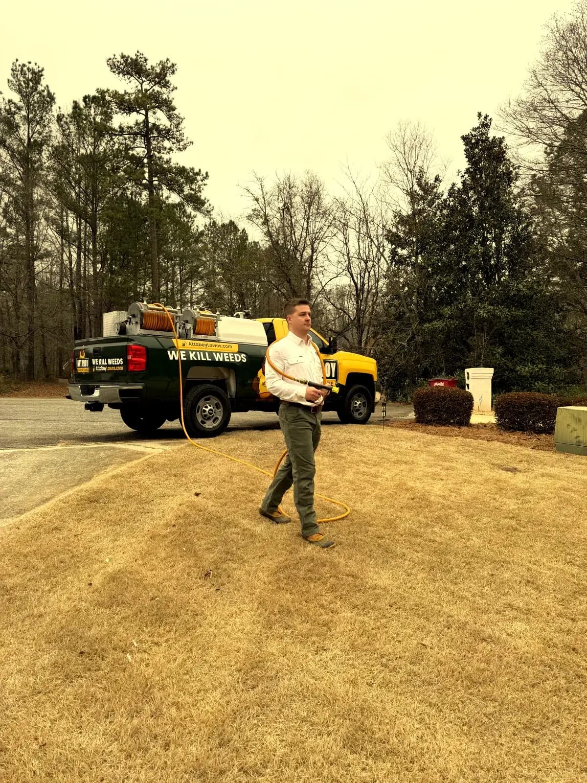 Tyler Warnock, founder and owner of Attaboy Lawn Care, with service truck
